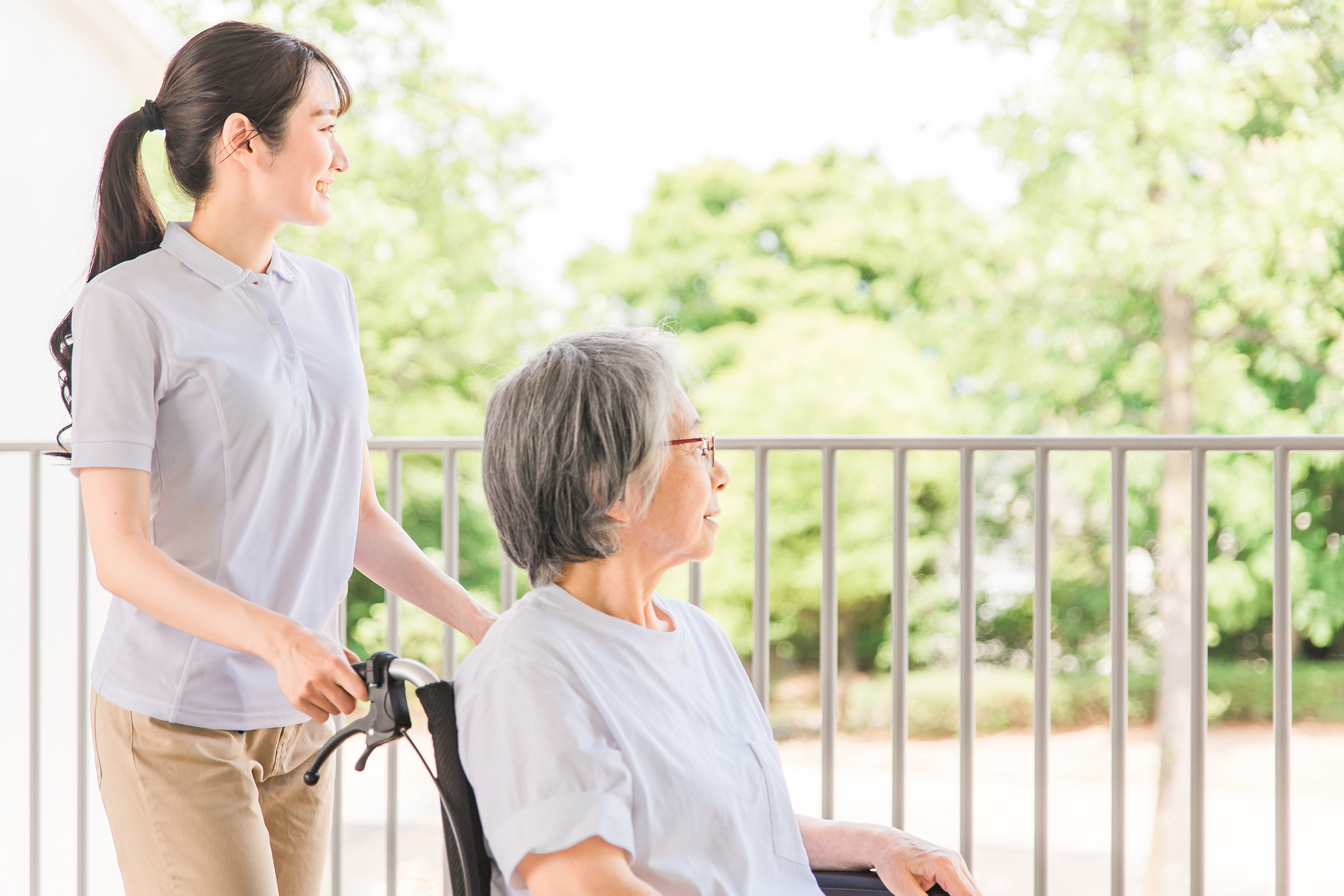 車椅子を利用する方に寄り添う介護スタッフ